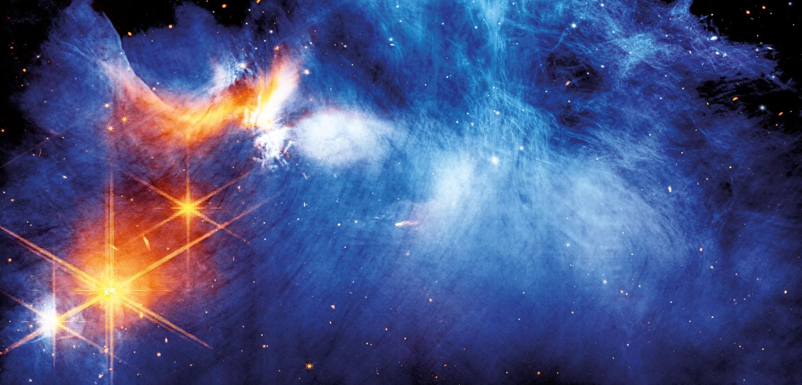 Centrum obłoku molekularnego Kameleon I. Zimna materia (kolor niebieski) oświetlana jest przez protogwiazdę Ced 110 IRS 4 (pomarańczowy).