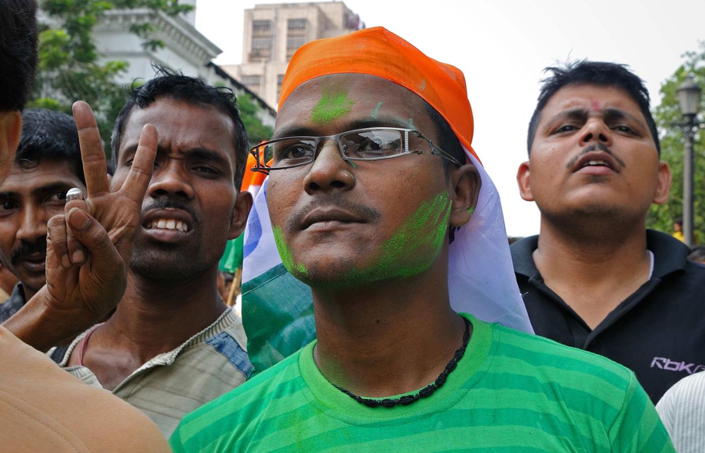 Z czół ścieka zielony proszek. Niektórzy osłaniają głowy chustkami i partyjnymi sztandarami przed żarem lejącym się z nieba. Zielony znak na czole to symbol poparcia dla partii nowej premier.