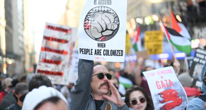 Manifestacja poparcia dla Palestyńczyków na Times Square w Nowym Jorku. Mężczyzna trzyma kartkę z napisem: Opór jest uzasadniony, gdy ludzie są kolonizowani. 13 października 2023 r.