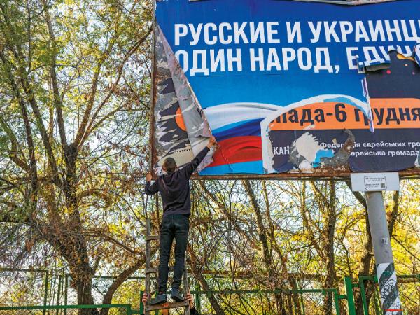 Rosjanie i Ukraińcy – jeden naród, jedna całość – nastolatek zrywa rosyjski billboard propagandowy w Chersoniu.