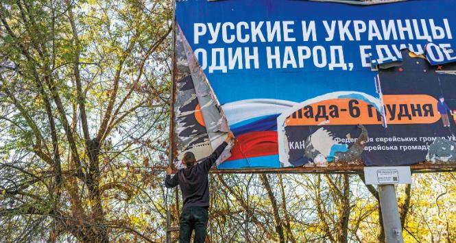 Rosjanie i Ukraińcy – jeden naród, jedna całość – nastolatek zrywa rosyjski billboard propagandowy w Chersoniu.