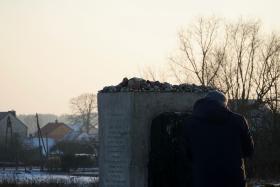 Obelisk znajdujący się na terenie dawnej stodoły, gdzie doszło do pogromu Żydów. Przed pomnikiem stoi fotograf, który towarzyszy dziennikarzom z czeskiego radia.