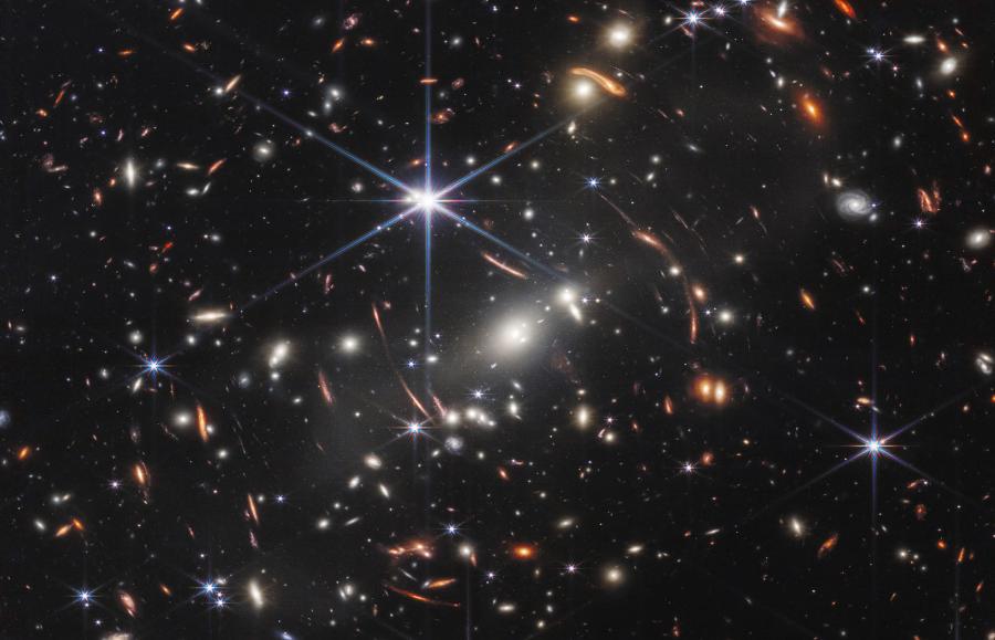 Tzw. Głębokie Pole Webba. Jedno z pierwszych zdjęć uzyskanych przez James Webb Space Telescope. Ukazuje daleką gromadę galaktyk SMACS 0723 i soczewkowaną przez nią galaktykę leżącą znacznie dalej za nią, w odległości ponad 12 mld l.ś. od nas.