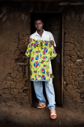 Kamara Ntakirutimana, 18 lat. Rodzice nie żyją, mieszka sam, co dzień szuka pracy dorywczej. KOSZULĘ kupił za własne pieniądze. Chce iść na studia i zostać nauczycielem matematyki i fizyki. Studia dadzą mu niezależność finansową. Rutshuru, DR Kongo
