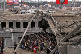 Mieszkańcy Irpienia w obwodzie kijowskim chowają się przed ostrzałami pod zniszczonym mostem.