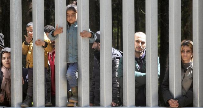 Grupa uchodźców z dziećmi za zaporą na granicy polsko-białoruskiej. Proszą o azyl i ochronę międzynarodową. 28 maja 2023 r.