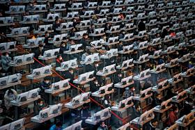 Handlowcy w chińskim Kunmingu pracują bez przerwy, ale w maskach i z zabezpieczonymi folią komputerami.