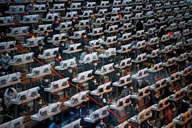 Handlowcy w chińskim Kunmingu pracują bez przerwy, ale w maskach i z zabezpieczonymi folią komputerami.