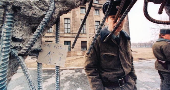 Wschodnioniemiecki strażnik graniczny przy wyłomie w murze berlińskim, Berlin, luty 1990 r.
