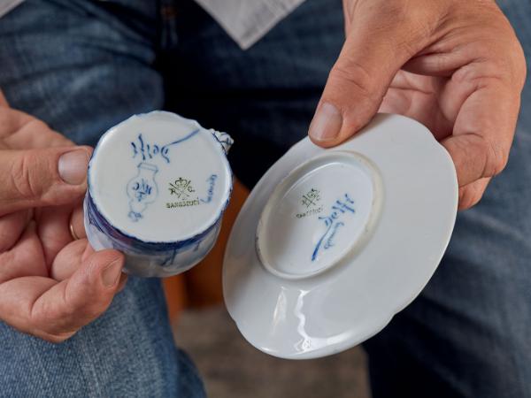 Pod lupą. Różne logotypy i sygnatury pozwalają prześledzić wędrówkę filiżanki z miejsca jej produkcji do pracowni artystycznych, gdzie była dekorowana mechanicznie lub malowana ręcznie. Dzięki tym stemplom można też w miarę dokładnie określić czas powstania cennego obiektu.