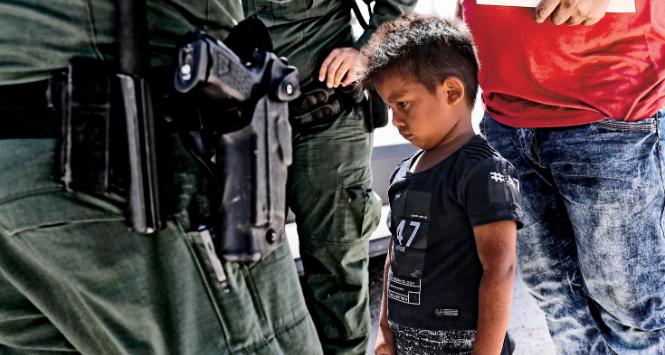 Uchodźcy z Hondurasu (ojciec z synem) aresztowani przez straż na granicy meksykańsko-amerykańskiej.