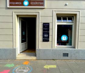 Książkoteka, Kraków, ul. Dolnych Młynów 3/11. Dlaczego warto prowadzić księgarnię kameralną?Księgarnie niezależne, moim zdaniem, mogą sobie pozwolić na bliższy i bardziej bezpośredni kontakt z klientem. Mam okazję poznać klientów, doradzić im, porozmawiać, w niektórych przypadkach nawet się zaprzyjaźnić. Zadowolony klient zostaje z nami na dłużej – znam ich gust (przede wszystkim gust małych odbiorców – mogę ich podpytać o wrażenia z lektury i czerpać wiedzę zwrotną wprost od grupy docelowej :) Dzięki temu, ze nie jestem częścią żadnej sieci, mogę sobie pozwolić na selekcję zamawianych tytułów wg gustu swojego i swoich klientów, promować tytuły, w które wierzę, nie ulegać presji jakiejś odgórnej idei marketingowej. I przede wszystkim sama sobie jestem sterem i odpowiadam tylko przed sobą. Myślę, że księgarnie niezależne są bardziej przyjazne dla klientów, nawet jeżeli nie mogą pozwolić sobie na znaczne zniżki czy akcje rabatowe. Kupujący nie czują się  anonimowi – a to (moim zdaniem) zaleta.2. Skąd pomysł na taką, a nie inną nazwę księgarni?Nazwę księgarni wymyślił mój syn (Bruno, aktualnie lat prawie 10, wtedy 7). Jest wybitnym 'kociarzem', stwierdził więc, że w nazwie koniecznie musi być kot - najlepiej i kot i książka. Wypisywaliśmy różne połączenia słów i najbardziej spodobała mu się nazwa 'KsiażKOTeka' - bo i książka, i kot brzmi trochę jak biblioteka, a w bibliotece też są książki (taki był jego tok rozumowania) – zostaliśmy więc przy Książkotece. — Kinga Borowiecka-Woźniakiewicz.