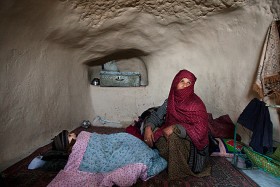 Yacob, na zdjęciu z babcią, ma prawie cztery lata. W wieku siedmiu miesięcy zachorował na cholerę i został sparaliżowany. Od tego czasu leży w tym samym miejscu. We wsi Moleyen ludzie żyją w jaskiniach, które adaptują na domy. Prowincja  Bamian, 2009