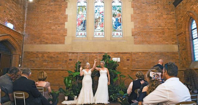 Rebecca Hickson (po lewej) i Sarah Turnbull pozują do zdjęć po ślubie podczas ceremonii w Newcastle, Australia. Małżeństwa osób tej samej płci zalegalizowano tu w 2017 r.
