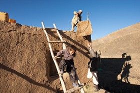 Ojciec z synem i sąsiadem uszczelniają dach przed nadejściem śniegu. Wieś, w której mieszkają, położona jest daleko od głównych szlaków, a do najbliższej szkoły jest ponad trzy godziny drogi. Do szkoły chodzi tylko czworo starszych dzieci.  Bedqol, 2009