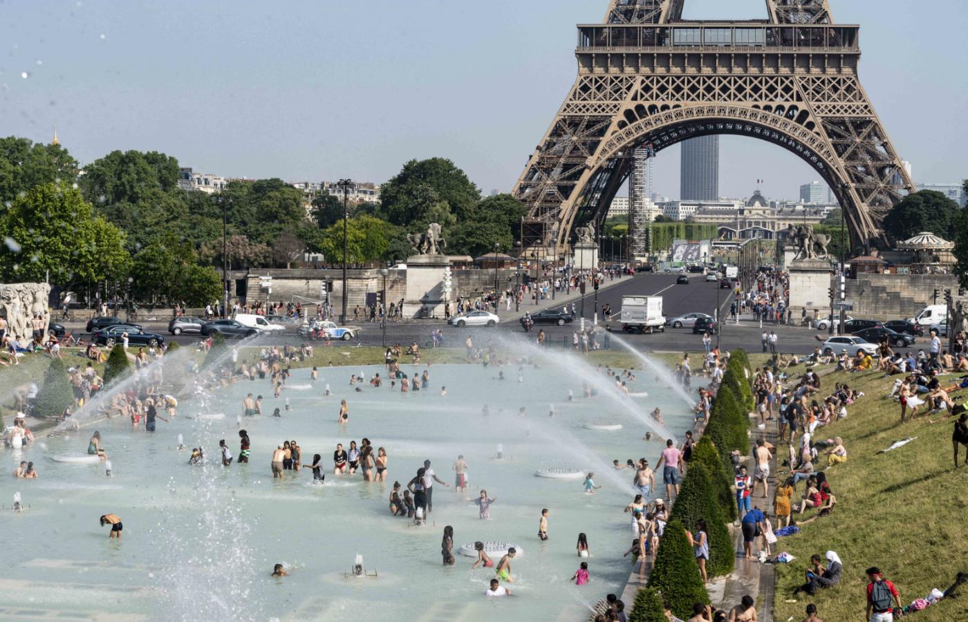 Paryżanie i turyści chłodzą się przy fontannie na pl. Trocadero.