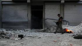 Żołnierz Armii Wolnej Syrii patrolujący zgliszcza w Aleppo.