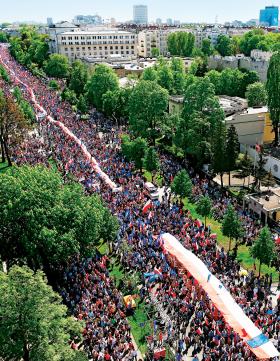 Rzeka ludzi płynie Alejami Ujazdowskimi w Warszawie w stronę Placu Piłsudskiego.