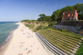 Plaża i ruiny kościoła w Trzęsaczu. Świątynia pierwotnie wzniesiona została w odległości ok. 2 km od brzegu morza, uległa zniszczeniu w wyniku procesów abrazyjnych.